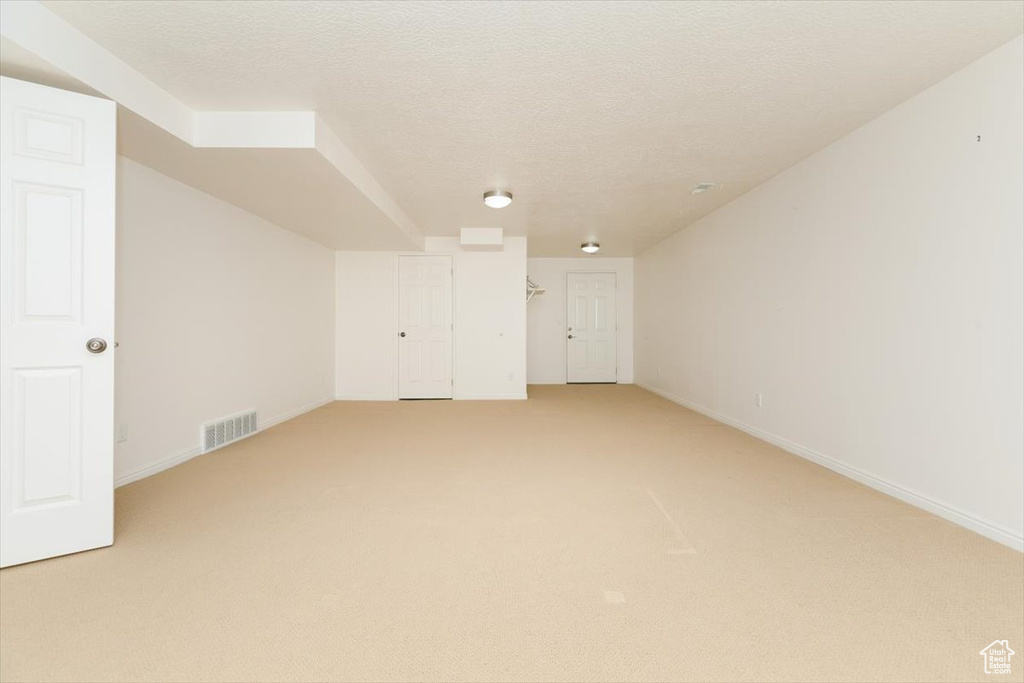 Bonus room featuring light colored carpet and a textured ceiling