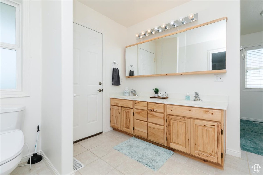 Bathroom with double vanity and tile patterned flooring