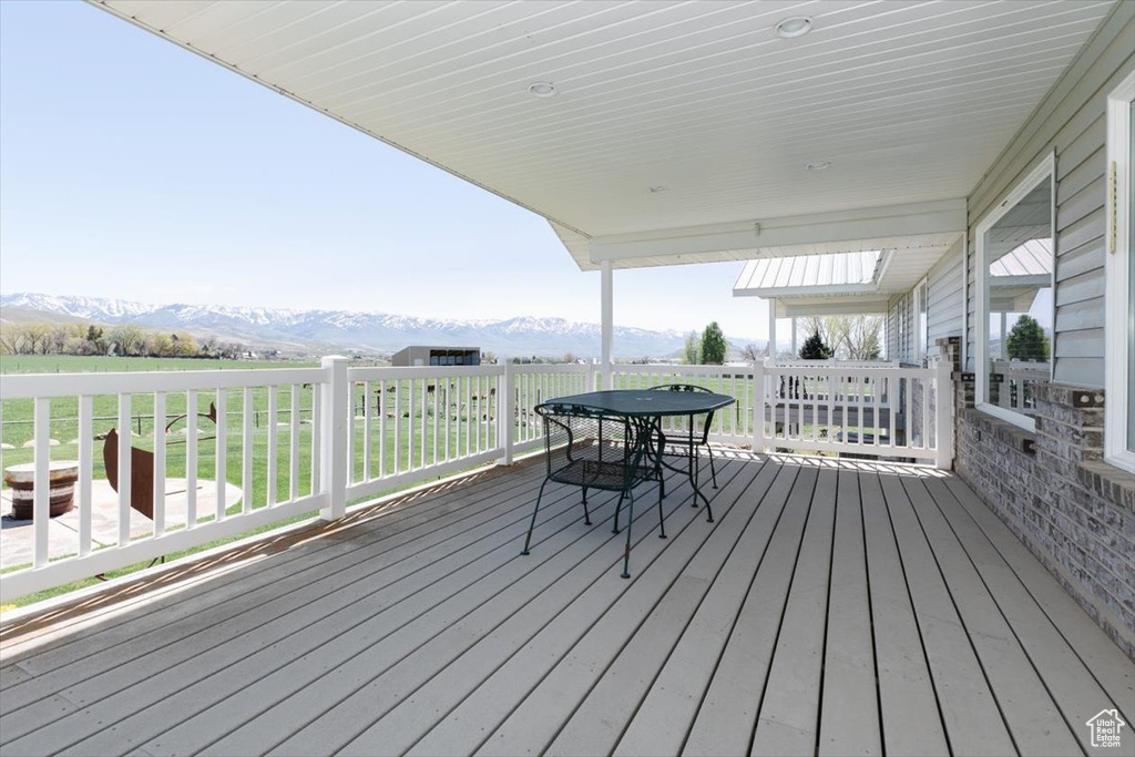 Wooden deck with a mountain view and outdoor dining space