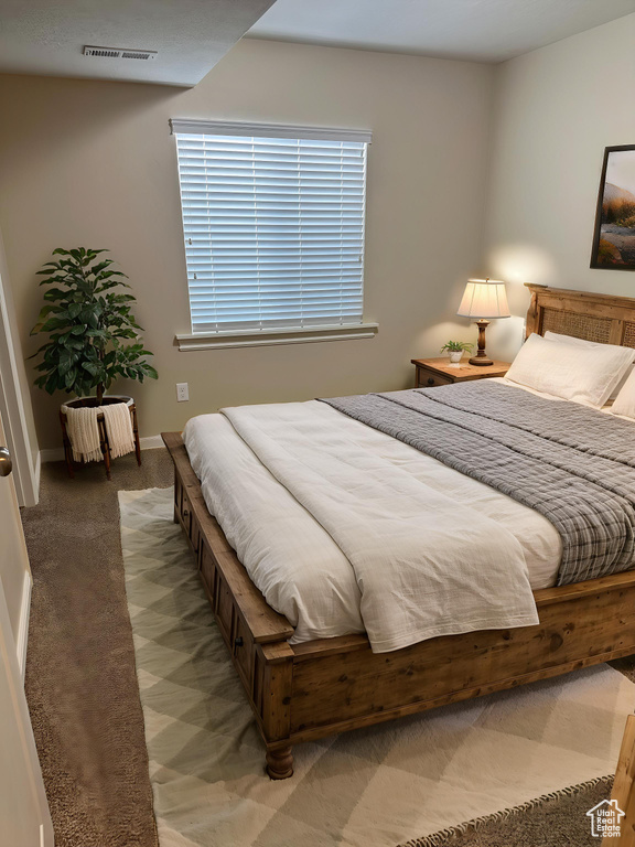Bedroom featuring light carpet, visible vents, and baseboards