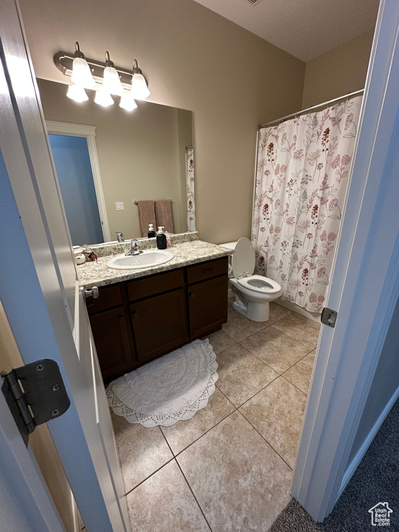 Bathroom featuring tile patterned flooring, vanity, and toilet