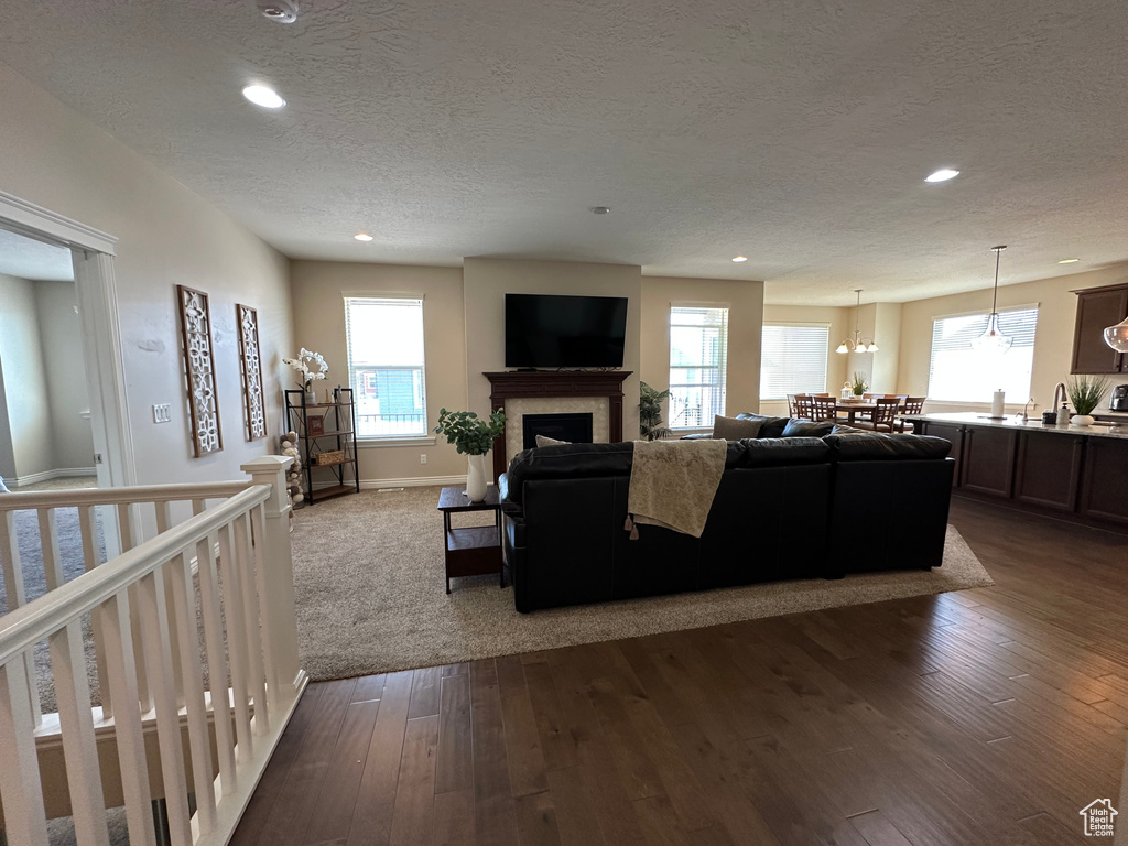 Living room with plenty of natural light, a textured ceiling, and dark wood finished floors