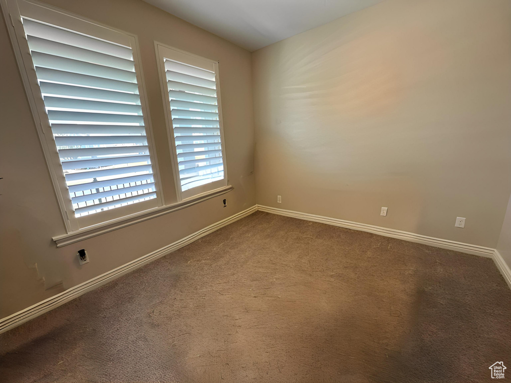 Spare room featuring baseboards and carpet flooring