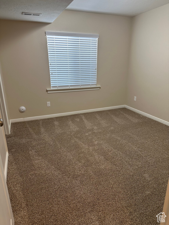 Unfurnished room featuring baseboards, visible vents, and carpet floors