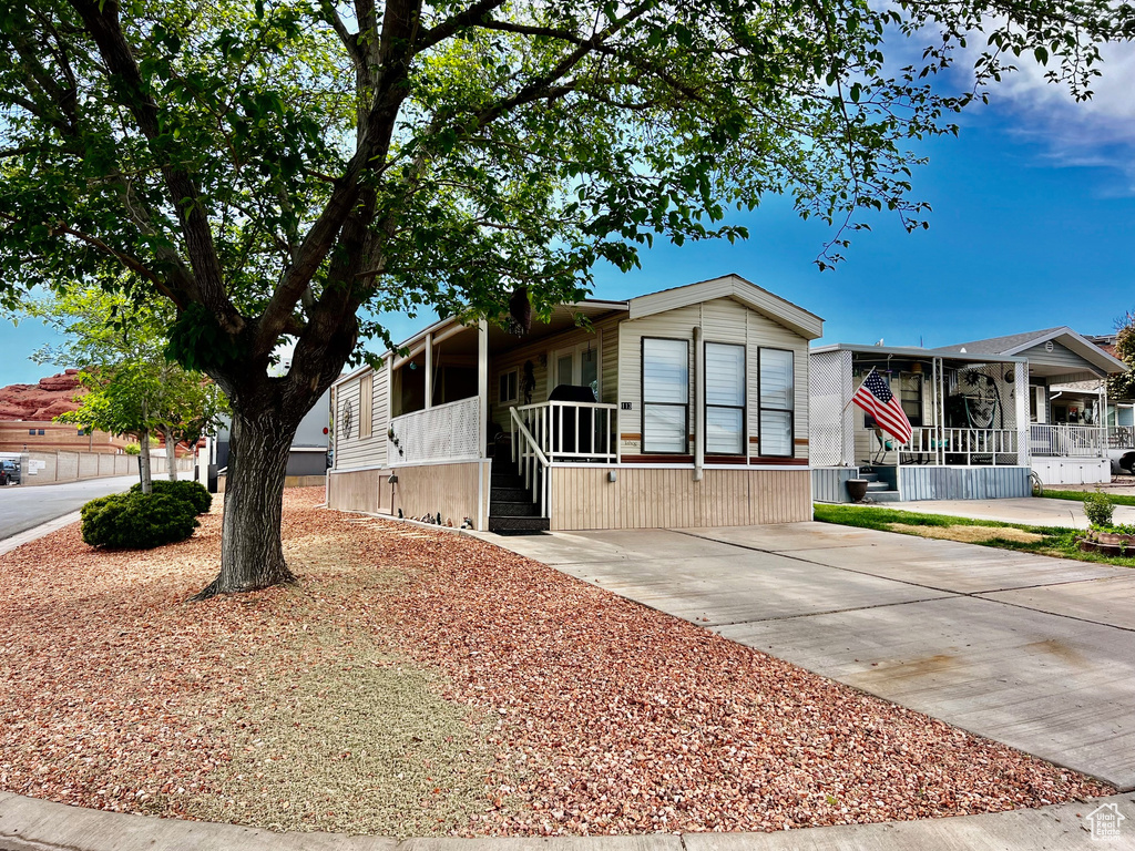 Manufactured / mobile home featuring a sunroom, driveway, and covered porch