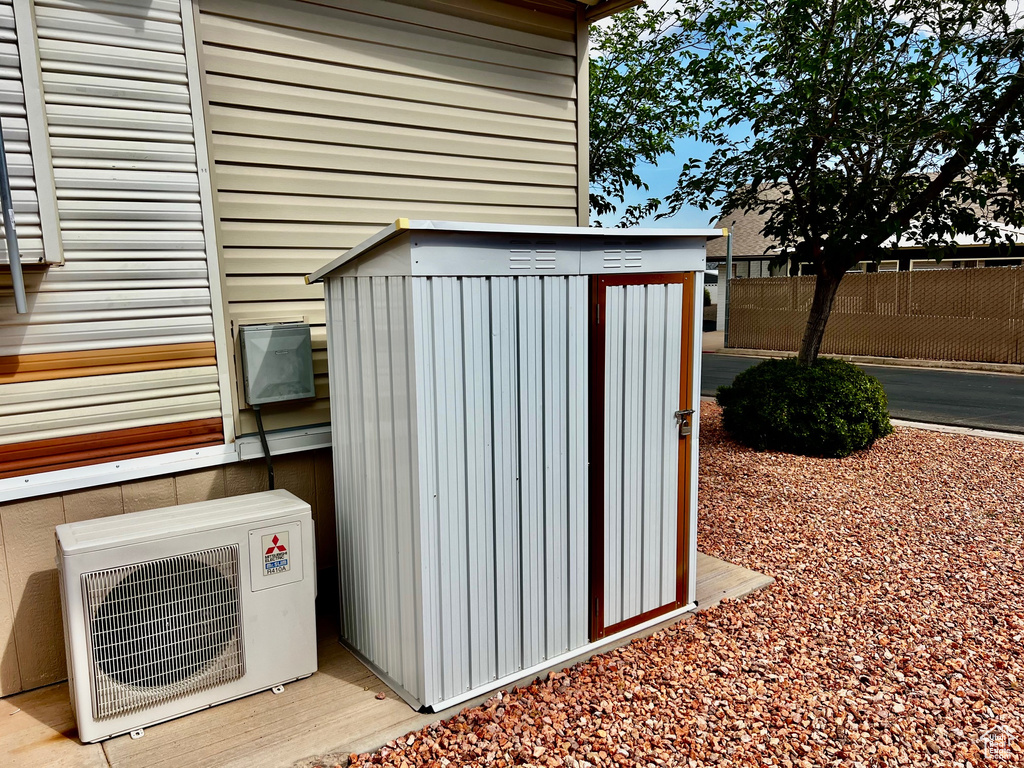View of shed with ac unit and fence