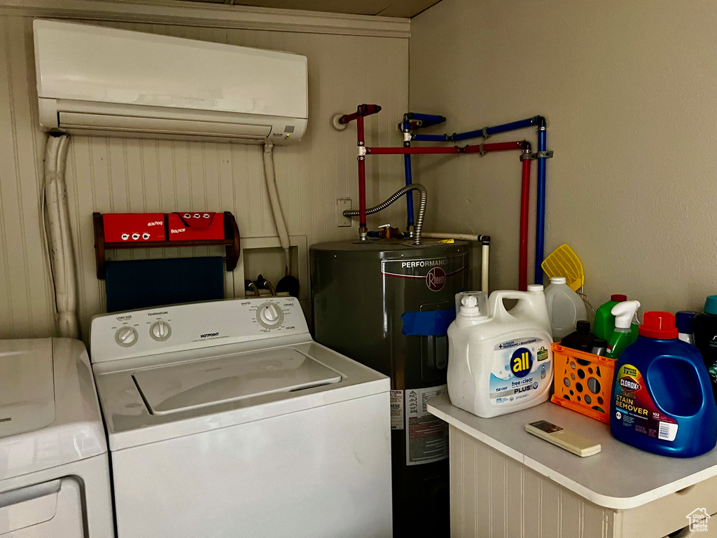 Clothes washing area with water heater, a wall mounted AC, washing machine and dryer, and laundry area