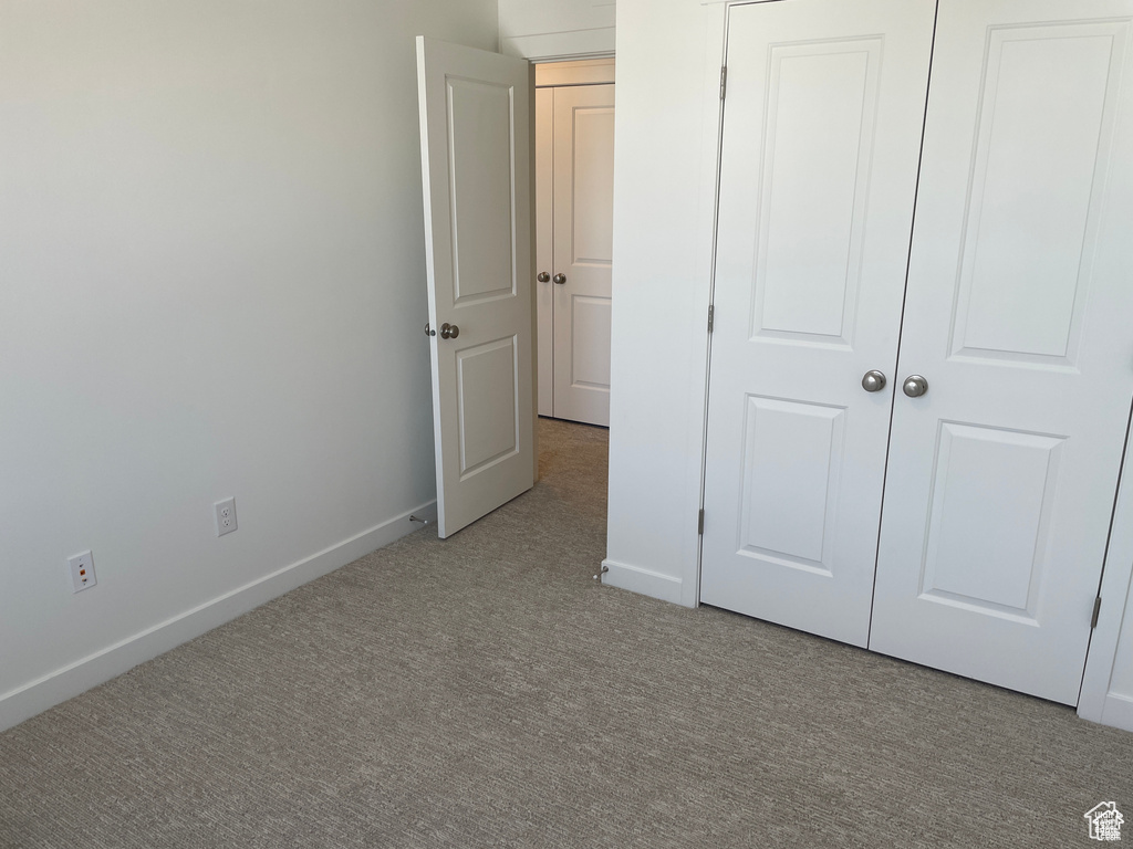 Unfurnished bedroom with carpet and baseboards
