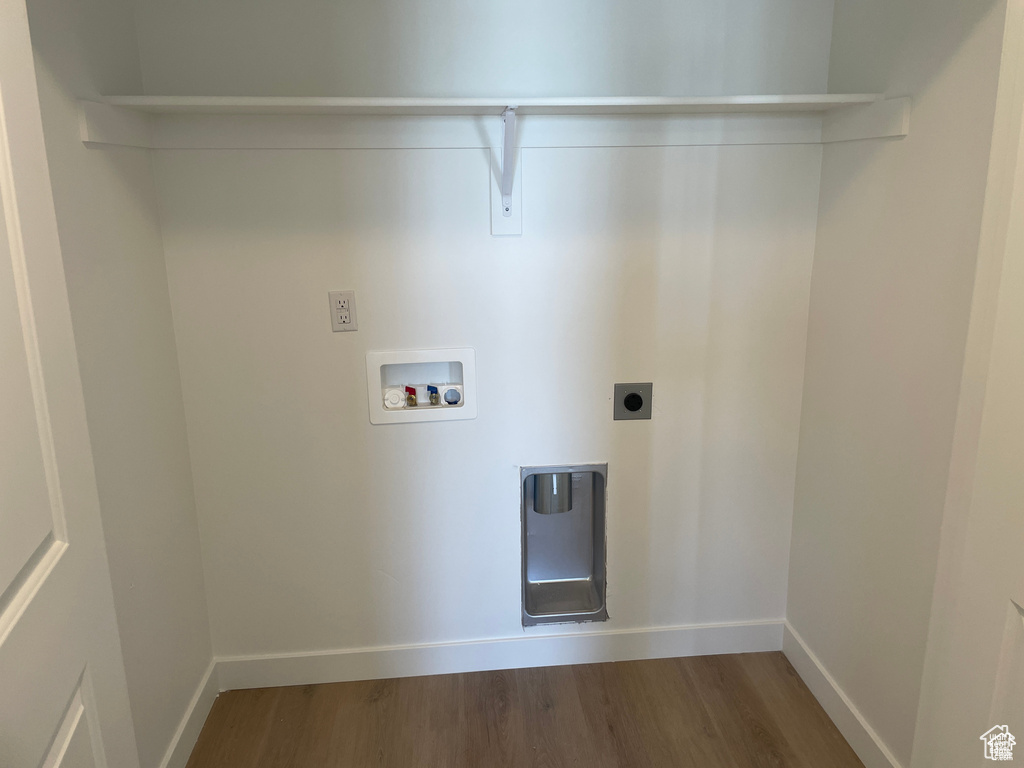 Washroom with hookup for a washing machine, wood finished floors, electric dryer hookup, baseboards, and laundry area