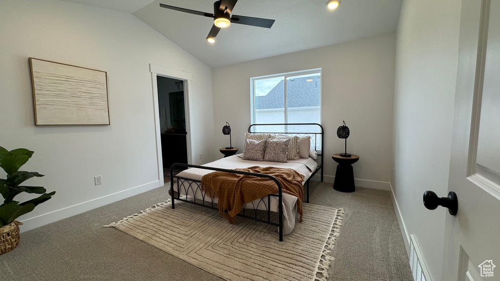 Carpeted bedroom with baseboards, a ceiling fan, and vaulted ceiling