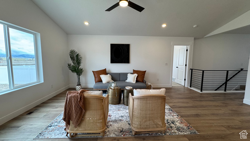 Living area with wood finished floors, a ceiling fan, lofted ceiling, and recessed lighting