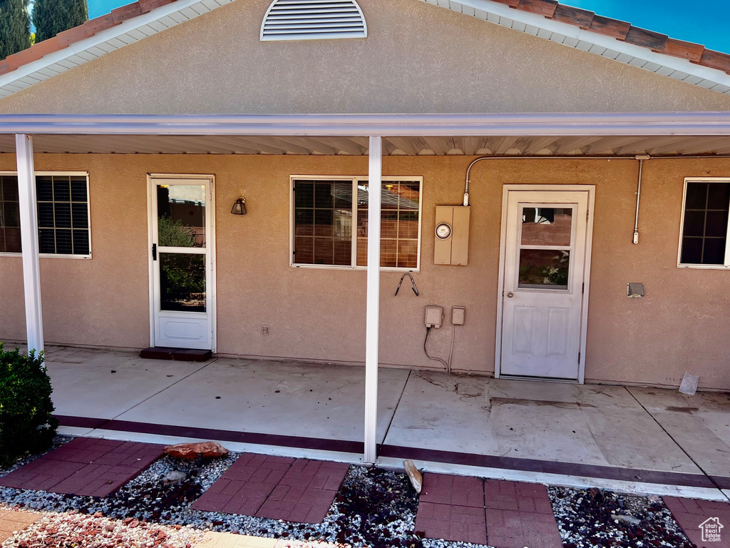 Entrance to property featuring a patio and stucco siding