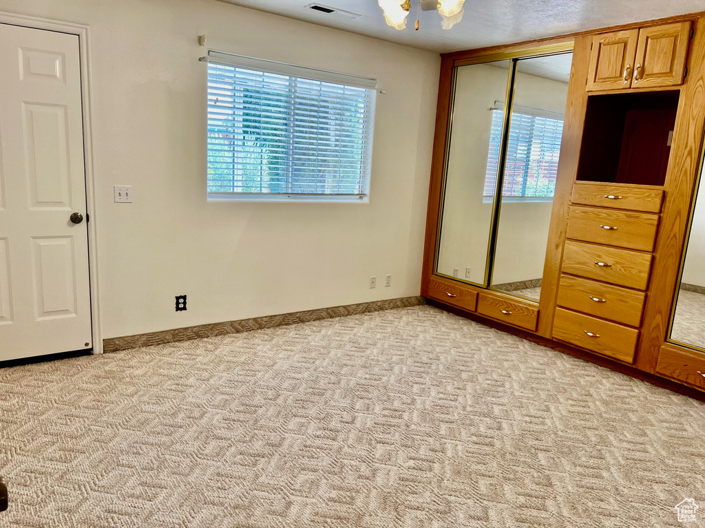 Unfurnished bedroom featuring light carpet and a closet