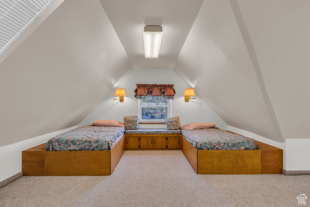 Bedroom featuring light carpet and vaulted ceiling
