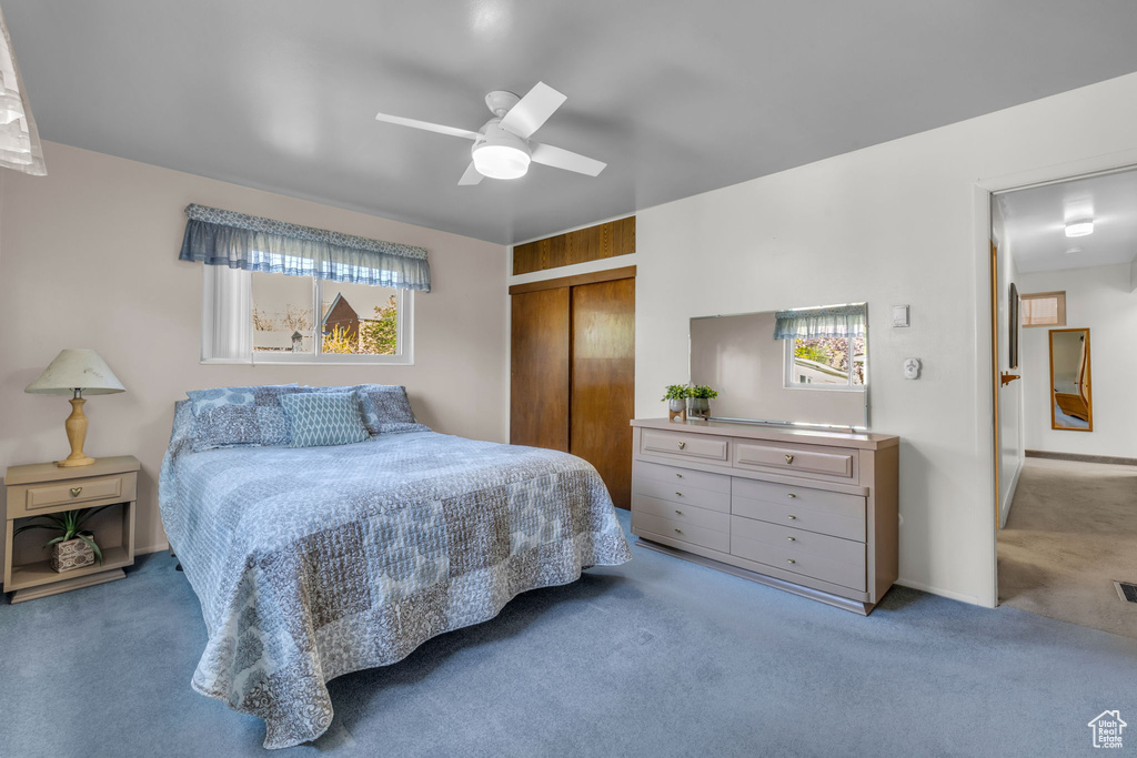 Carpeted bedroom featuring a closet and ceiling fan