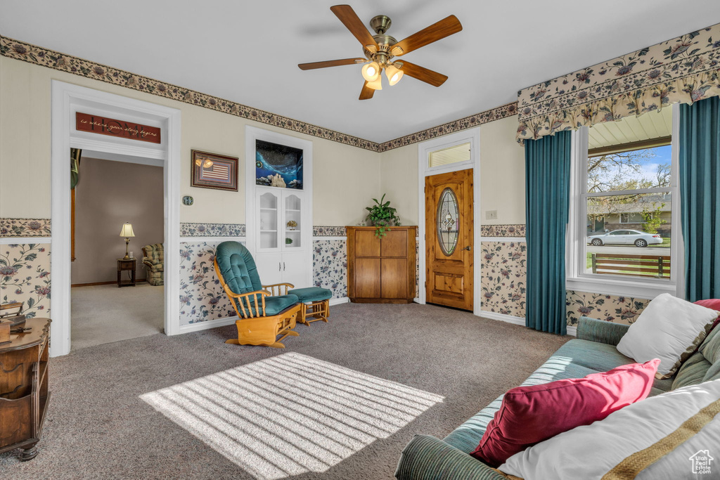 Carpeted living room with baseboards and a ceiling fan