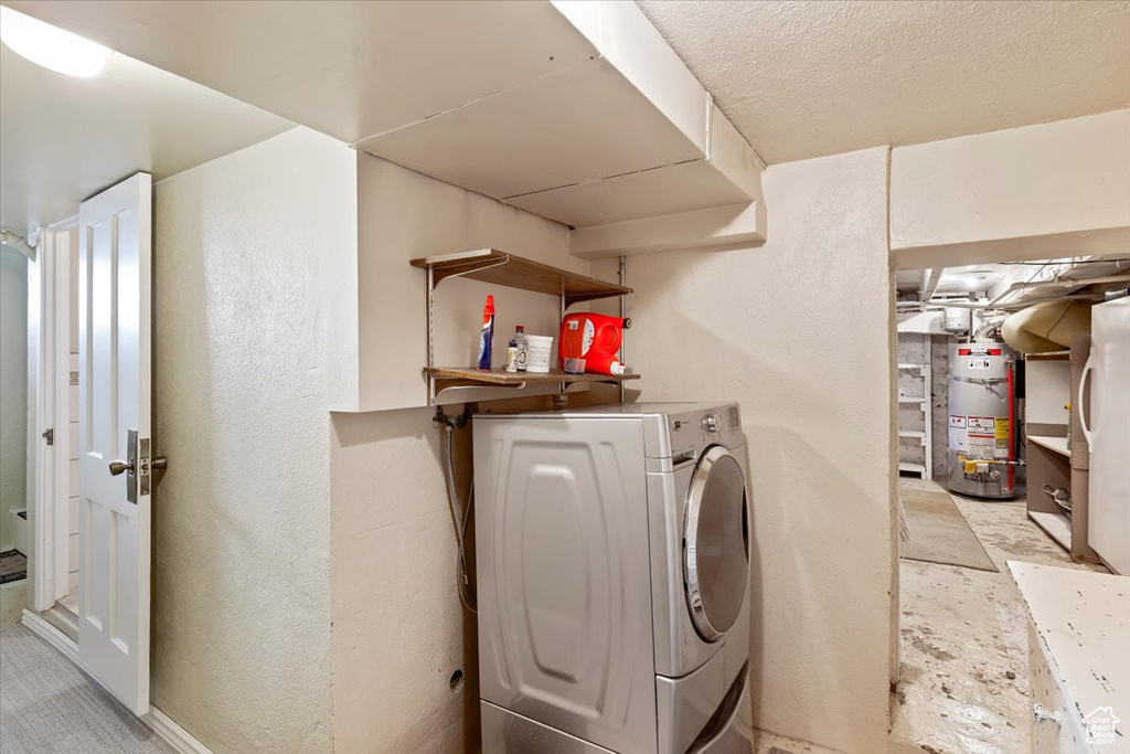 Laundry area featuring water heater, laundry area, and washer / clothes dryer