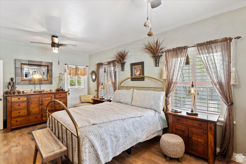 Bedroom featuring light wood-style flooring, ceiling fan, and multiple windows