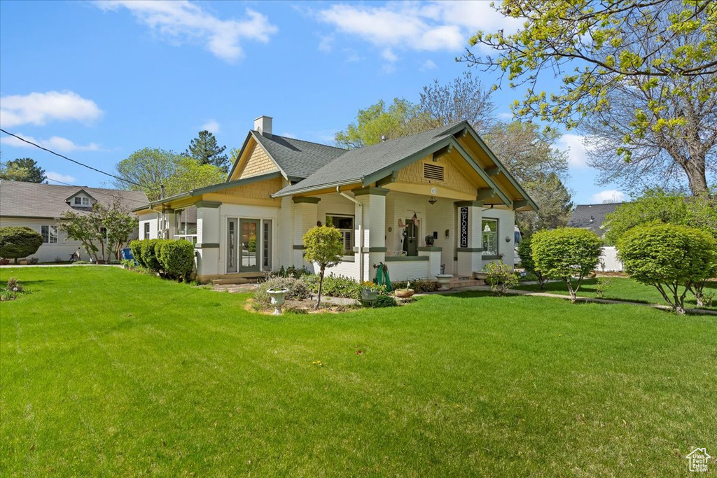 Rear view of house featuring a lawn and a chimney