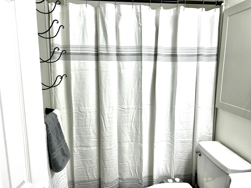 Full bath featuring a shower with shower curtain and toilet