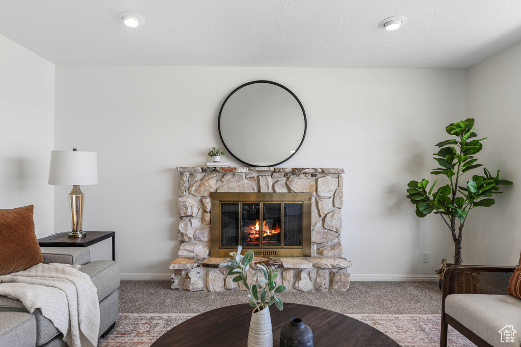Carpeted living room with baseboards and a fireplace