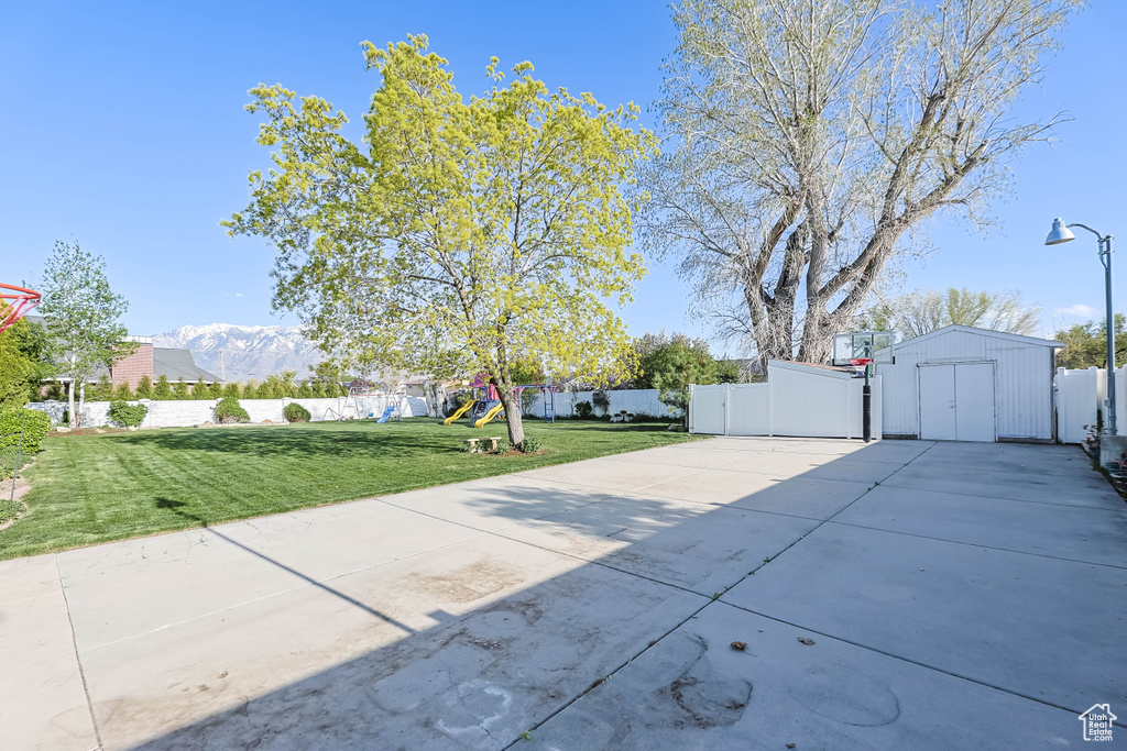 View of patio / terrace featuring fence, driveway, and a playground