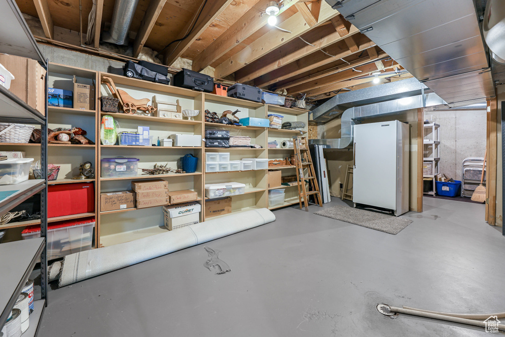 Unfinished below grade area with freestanding refrigerator