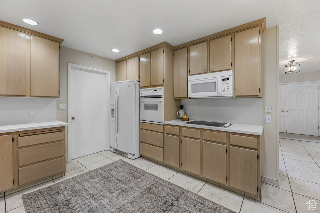 Kitchen featuring light tile patterned floors, recessed lighting, white appliances, and light countertops