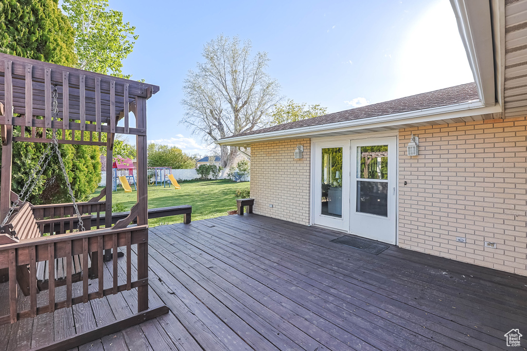 Wooden terrace featuring a yard and a playground