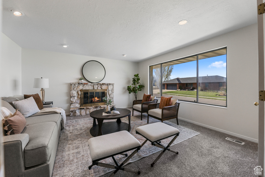 Living area with carpet, a fireplace, baseboards, visible vents, and recessed lighting