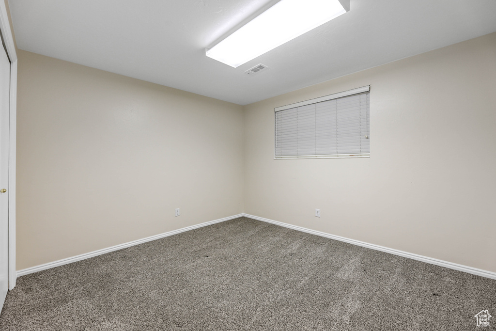 Unfurnished room with baseboards, visible vents, and carpet