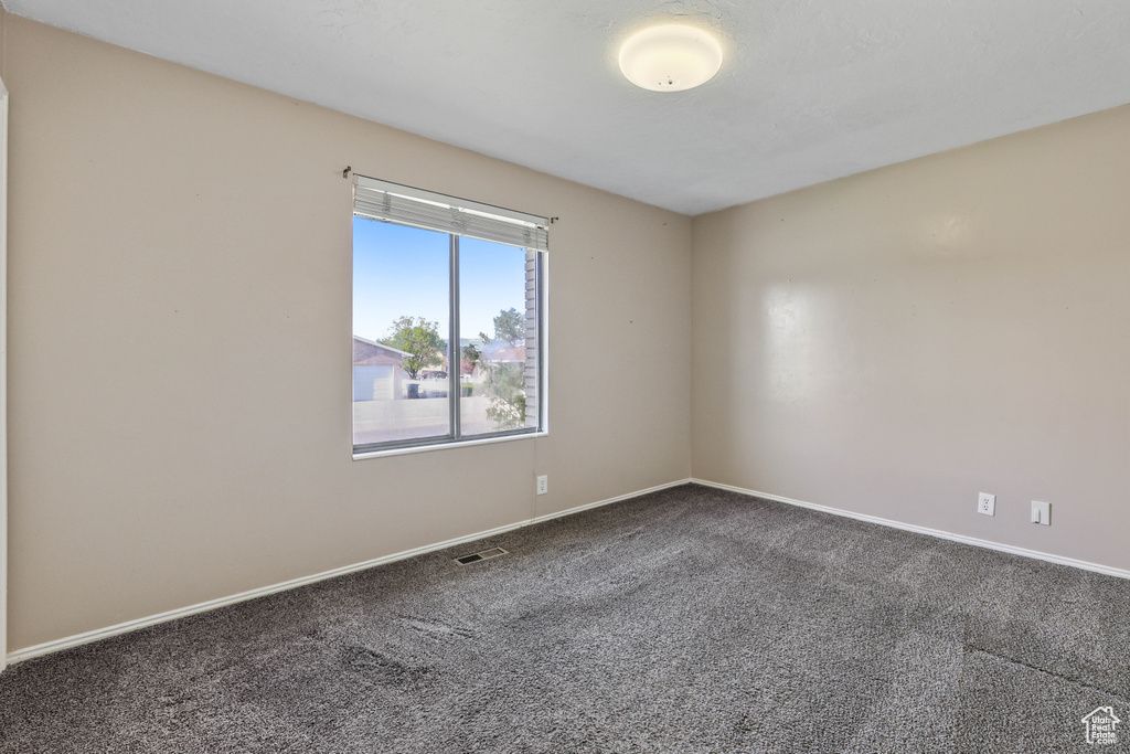 Empty room featuring visible vents, baseboards, and carpet floors