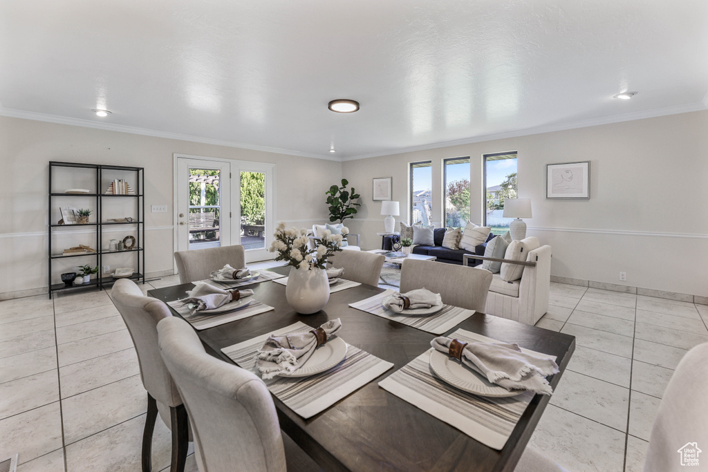 Dining area featuring a healthy amount of sunlight, ornamental molding, and light tile patterned floors