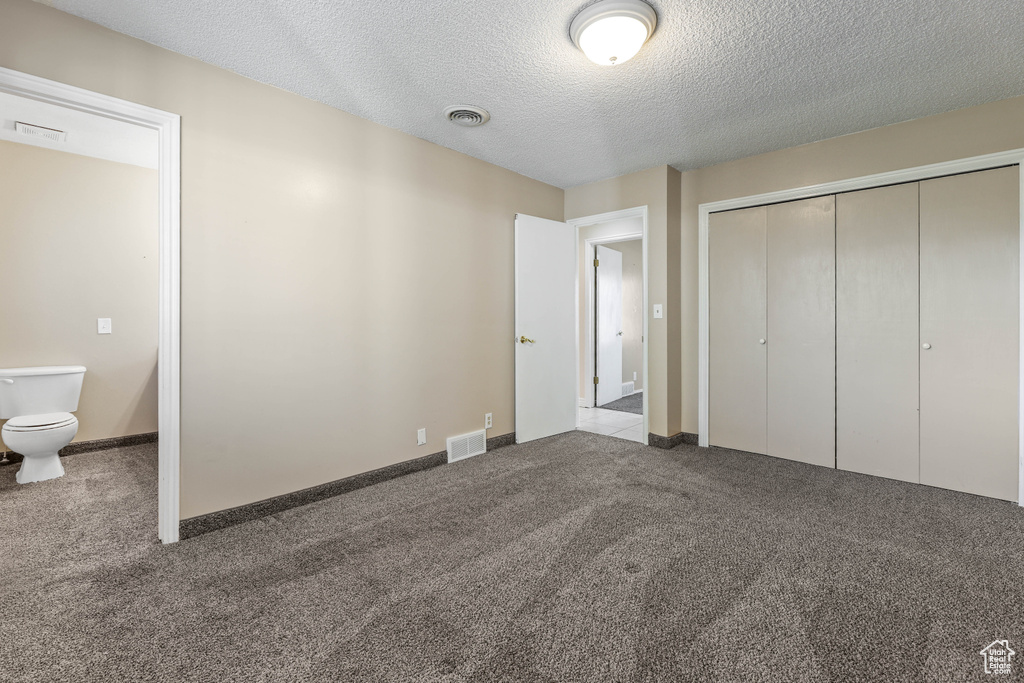 Unfurnished bedroom with visible vents and carpet flooring