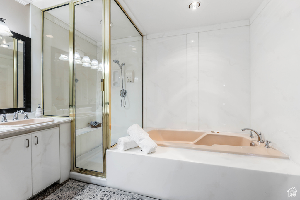 Bathroom with a bath, vanity, and a stall shower