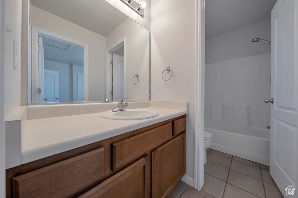 Full bath featuring tile patterned floors, vanity, bathtub / shower combination, and toilet
