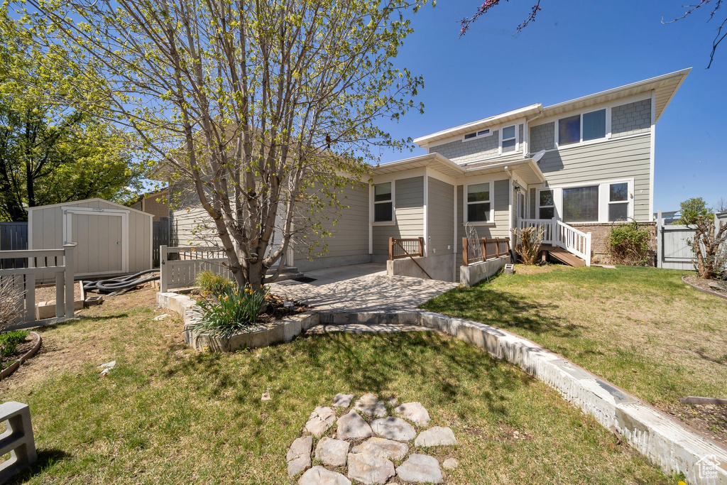 Back of house with a gate, fence, a shed, a patio area, and an outdoor structure