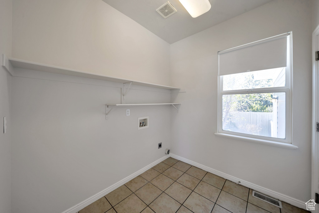 Clothes washing area with baseboards, visible vents, hookup for a washing machine, electric dryer hookup, and laundry area