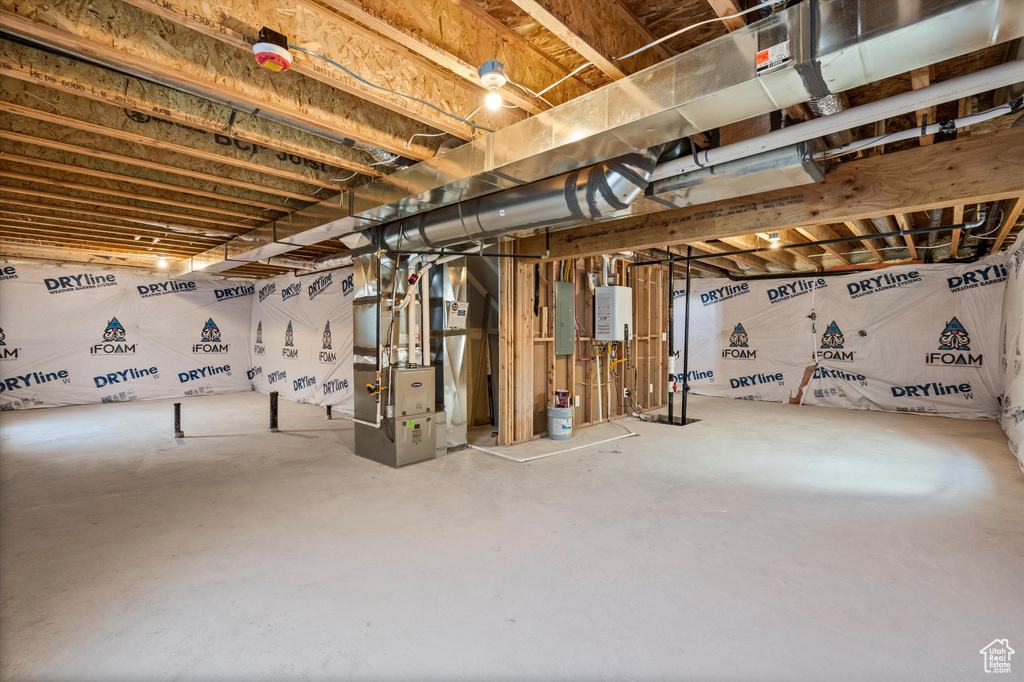 Unfinished basement featuring heating unit and tankless water heater
