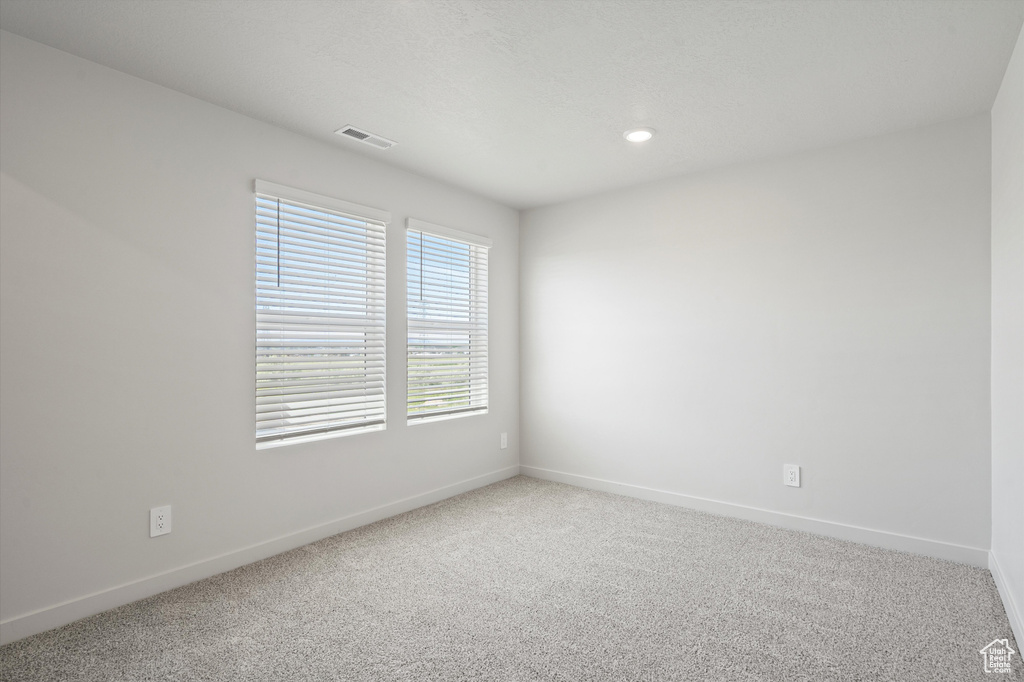 Carpeted spare room with baseboards and recessed lighting