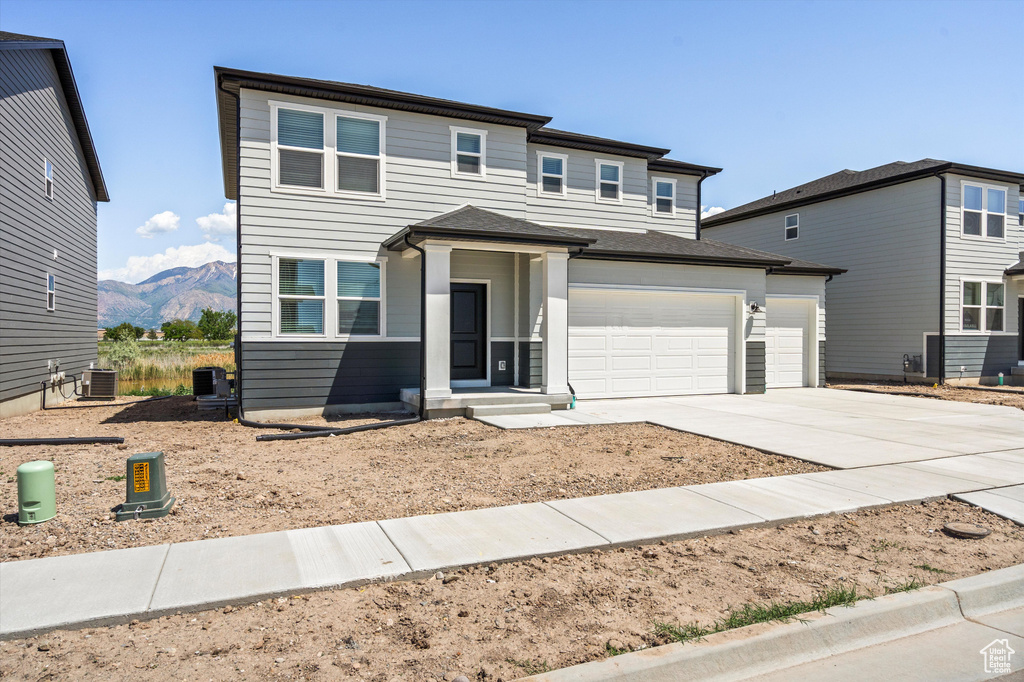Prairie-style home featuring driveway, a mountain view, and a garage