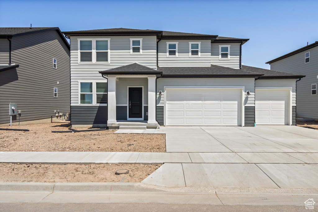 View of front of property with concrete driveway and a garage