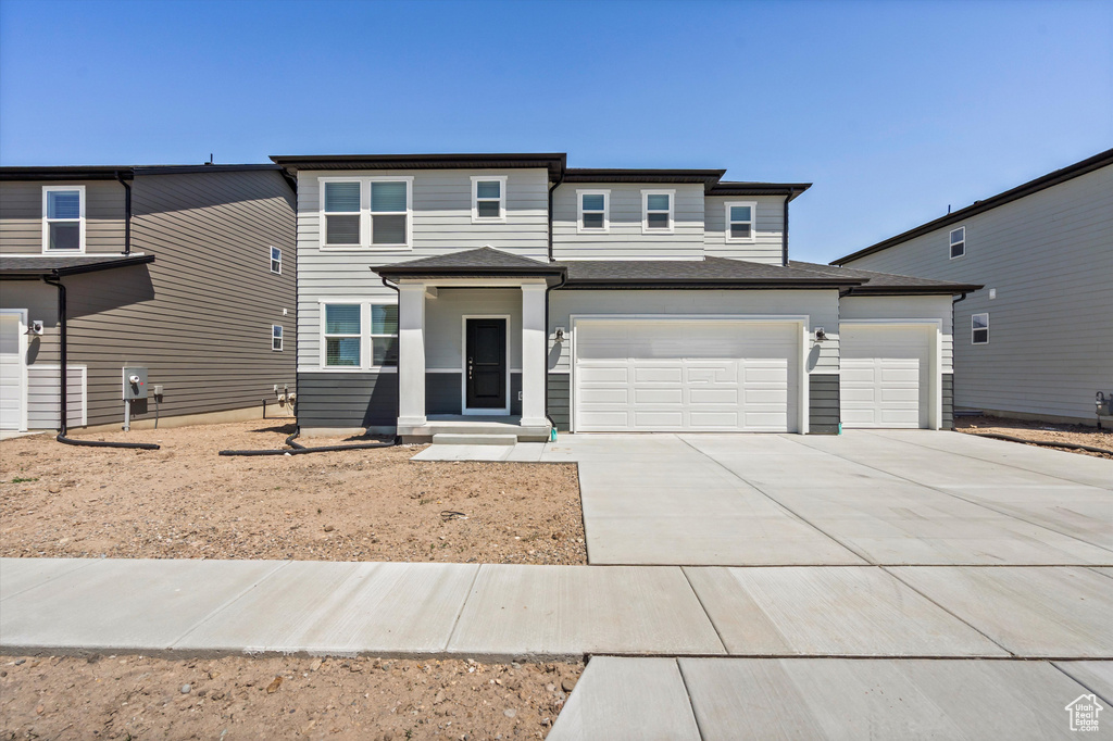 View of front of property with driveway and an attached garage