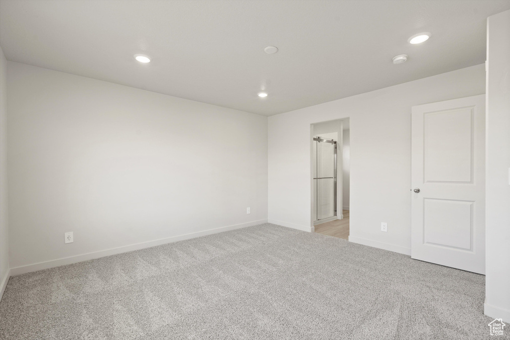 Unfurnished bedroom with light colored carpet and recessed lighting