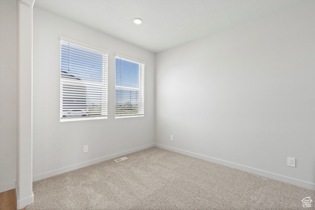Carpeted spare room with baseboards