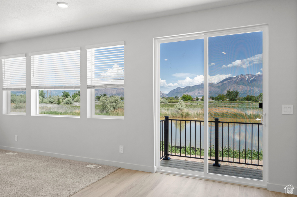 Spare room featuring a water and mountain view and wood finished floors