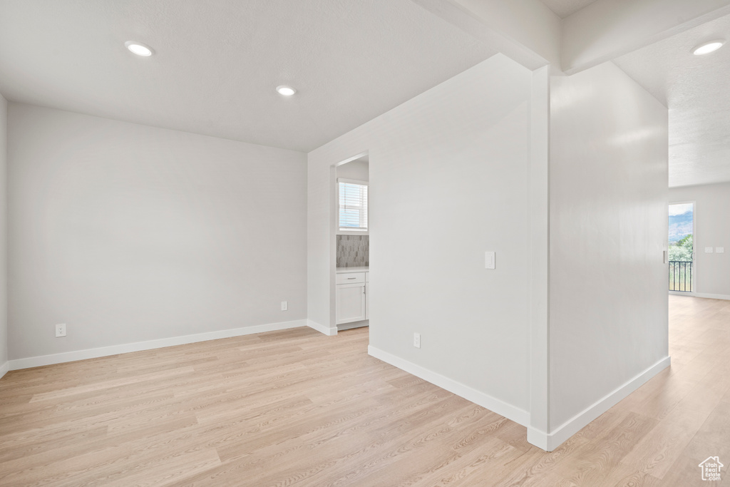 Spare room featuring light wood finished floors, recessed lighting, and baseboards