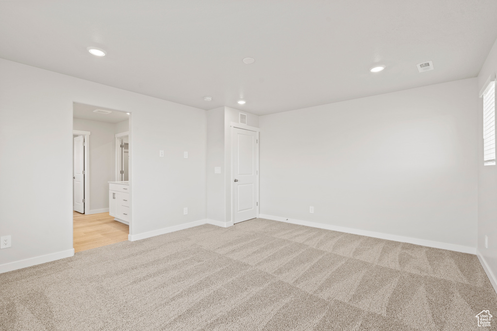 Empty room featuring light colored carpet, recessed lighting, and baseboards