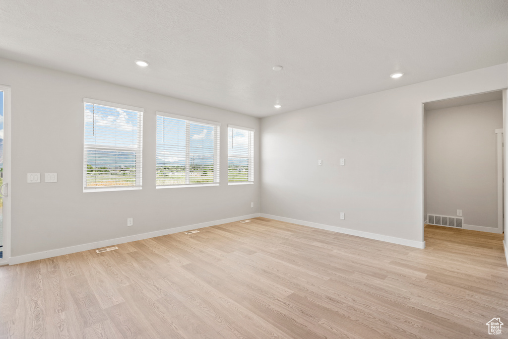 Unfurnished room featuring light wood finished floors, baseboards, and recessed lighting