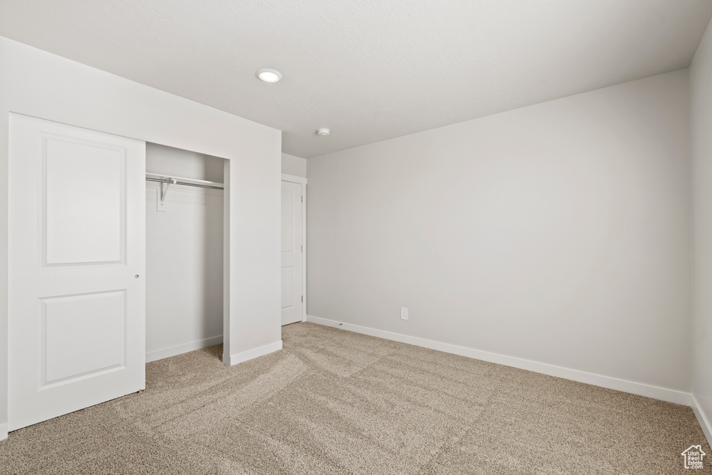 Unfurnished bedroom with carpet floors, a closet, baseboards, and recessed lighting